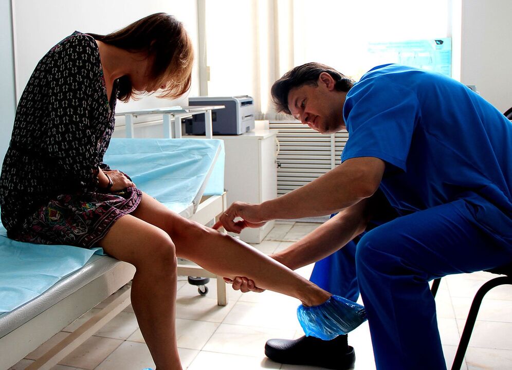 médecin examine la jambe avec des varices